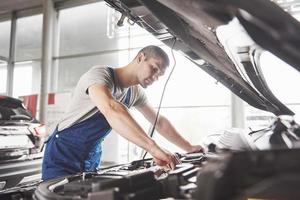 Auto mechanic working in garage. Repair service photo