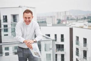 arquitecto joven sonriente o constructor de ingeniería con sombrero duro con tableta sobre un grupo de constructores en el sitio de construcción, arquitecto viendo algo de construcción, negocios, construcción, industria, concepto de personas foto