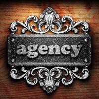 agency word of iron on wooden background photo