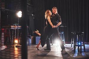 Skillful dancers performing in the dark room under the light photo