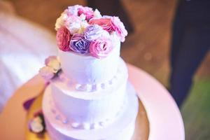 hermoso pastel de bodas con flores en la parte superior foto