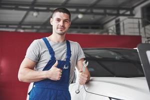 Hand of car mechanic with wrench. Auto repair garage photo