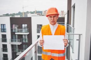 Young architect wearing a protective helmet standing on the mountains building outdoor background photo