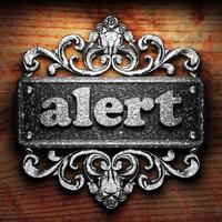 alert word of iron on wooden background photo