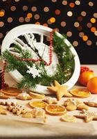 feliz año nuevo a la medianoche de 2018, viejo reloj de madera con luces navideñas y ramas de abeto. cocinar y decorar galletas de jengibre navideñas y rodajas de naranja frita