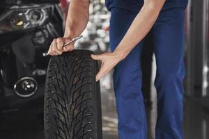 Close up of mechanic showing ok gesture with his thumb while holding a wrench photo