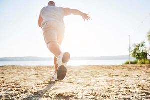 correr a campo traviesa al aire libre en el concepto de sol de verano para hacer ejercicio, estar en forma y un estilo de vida saludable. cerca de los pies de un hombre corriendo en la hierba foto