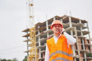 Young architect wearing a protective helmet standing on the mountains building outdoor background photo