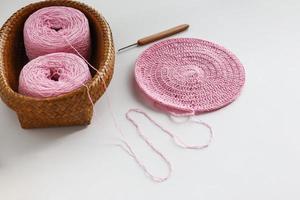 Crochet work and yarn ball in basket weaving with crochet needle. Handmade and craft. White background. photo