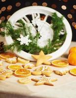 Happy New Year at midnight 2018, Old wooden clock with holiday lights and fir branches. Cooking and decorating christmas gingerbread cookies and fried orange slices photo