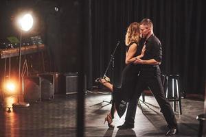 hábiles bailarines actuando en el cuarto oscuro bajo la luz foto