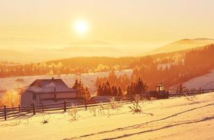 el misterioso paisaje invernal son majestuosas montañas en invierno. fantástica puesta de sol. grabando casas en la nieve. foto postal de cortesía. montes de Cárpatos