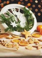 Happy New Year at midnight 2018, Old wooden clock with holiday lights and fir branches. Cooking and decorating christmas gingerbread cookies and fried orange slices photo