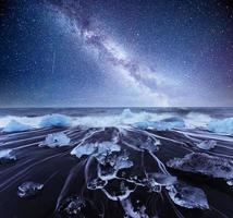 icebergs flotando en el lago glacial jokulsarlon. sur de islandia laguna. noche de cielo estrellado. fantástica vía láctea. foto