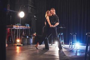 hábiles bailarines actuando en el cuarto oscuro bajo la luz foto