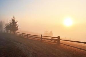 Amazing mountain landscape with fog and a haystack in autumn photo