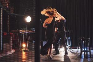 Skillful dancers performing in the dark room under the light photo