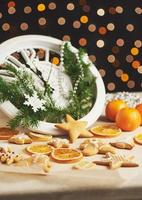 Happy New Year at midnight 2018, Old wooden clock with holiday lights and fir branches. Cooking and decorating christmas gingerbread cookies and fried orange slices photo