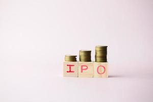 IPO text ,Initial Public Offering on wooden block with stack of coins photo