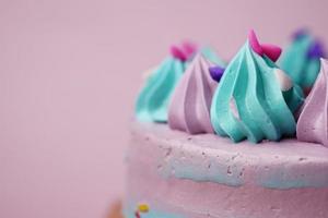 pastel de cumpleaños de color púrpura y verde sobre fondo de color foto