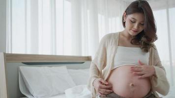schwangere frau trägt anti-dehnungsstreifen-bauchcreme auf, um narben am bauch zu verhindern video