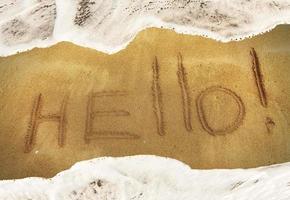 inscription HELLO on the black sand photo