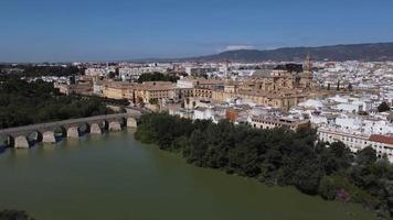 vista aérea da antiga cidade medieval de córdoba na andaluzia, espanha durante um dia ensolarado. catedral da mesquita medieval e ponte romana sobre o rio guadalquivir, patrimônio mundial da unesco. turismo. video