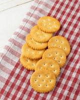 Cracker cookies with tablecloth on white wooden table background photo