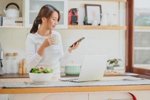 woman using smartphone mobile in the kitchen photo