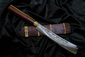 Knife custom in the natural rosewood casing on black background  handmade of Thailand