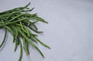 string beans on a white background. food material. source of vitamins. food menu for iftar. photo