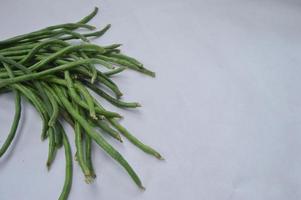 judías verdes sobre un fondo blanco. materia alimenticia. fuente de vitaminas. menú de comida para iftar. foto