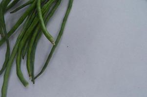 string beans on a white background. food material. source of vitamins. food menu for iftar.