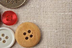 Sewing buttons of various sizes and colors on sackcloth. photo