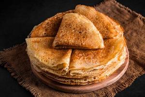 A stack of delicious pancakes on a black background. Food for the holiday Maslenitsa. photo
