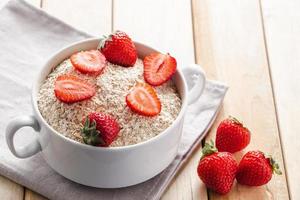 muesli de avena y fresas frescas sobre fondo de madera. foto