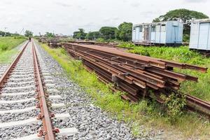 Overview of a railroad track and piles of cross ties lying photo