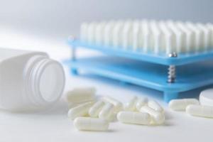 White pill capsules lay on floor  near white bottom