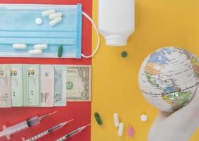 mapa en el globo en la mano, usando guantes médicos en el mundo, el problema de las epidemias tiene antecedentes son los billetes,
