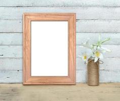 Old Wooden Frame mockup near a bouquet of sweet-william stands on a wooden table on a painted white wooden background. Vertical A4 Rustic style, simple beauty. 3d render. photo