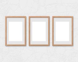 conjunto de 3 maquetas de marcos de madera verticales con un borde colgado en la pared. base vacía para imagen o texto. representación 3d foto