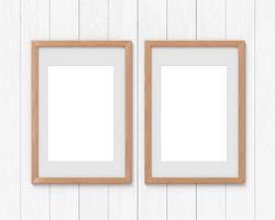 conjunto de 2 maquetas de marcos de madera verticales con un borde colgado en la pared. base vacía para imagen o texto. representación 3d