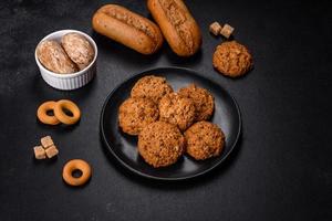 Tasty fresh oat cookies on a dark concrete background photo