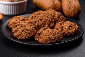 Tasty fresh oat cookies on a dark concrete background photo