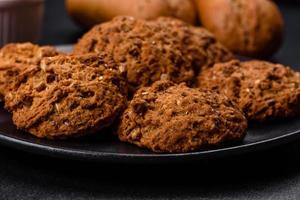 Tasty fresh oat cookies on a dark concrete background photo