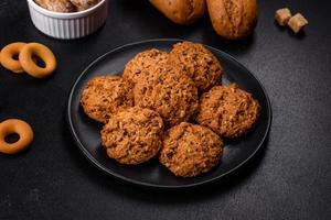 Tasty fresh oat cookies on a dark concrete background photo