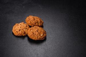 Tasty fresh oat cookies on a dark concrete background photo