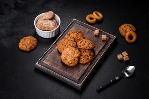 Tasty fresh oat cookies on a dark concrete background photo