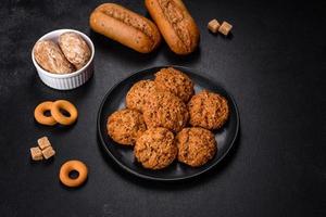 Tasty fresh oat cookies on a dark concrete background photo