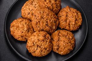 Tasty fresh oat cookies on a dark concrete background photo